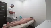 массажист делает клиентке массаж с маслом